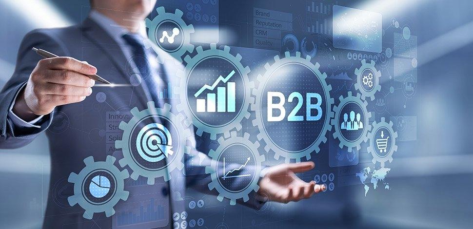 businessman pointing to a hologram of B2B and business symbols