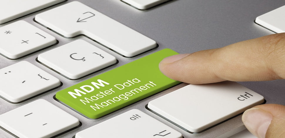 finger touches a green keyboard key with MDM Master Data Management written on it.