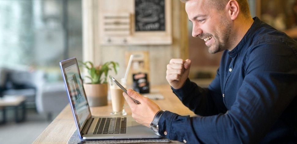 happy business owner uses PWA on laptop and mobile